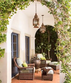 an outdoor patio with wicker furniture and potted plants