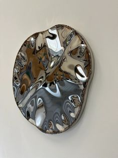 a circular mirror hanging on the side of a wall next to a white wall and floor