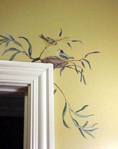 two birds sitting on top of a tree branch next to a framed wall art piece