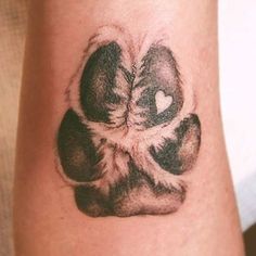 a tattoo on the arm of a person with a dog paw and heart in it