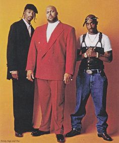 three men standing next to each other in front of a yellow wall wearing red suits and suspenders