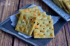 some crackers are on a blue plate and one is cut in half to look like cheese