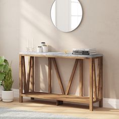 a wooden table with a mirror on the wall next to a potted plant and books