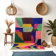 a multicolored area rug in the corner of a room next to two potted plants