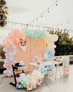 an outdoor party with balloons and decorations on the table, along with other items for decoration