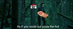 a man standing in the middle of a forest holding a piece of pizza with words on it