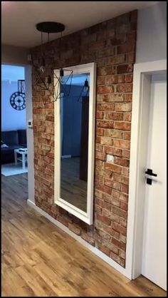 an empty room with a brick wall and large mirror on the wall, in front of a sliding glass door