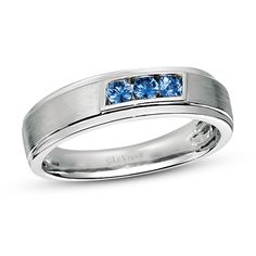 a men's wedding band with three blue sapphire stones in the center and two white diamonds on each side