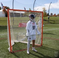 a lacrosse goalie is standing in front of the net