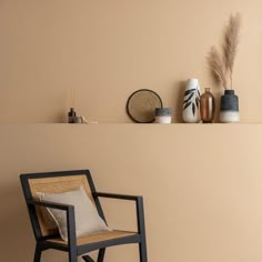 a chair and some vases on a shelf