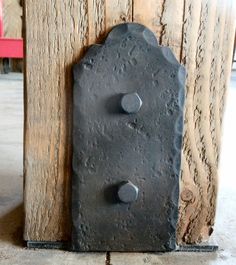 an old door handle with two knobs on the front and back of it, attached to a wooden post