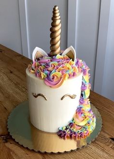 a cake decorated with a unicorn's head and rainbow sprinkles