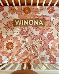 a close up of a window with a flowered curtain and the word winona on it