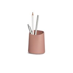 four pencils in a pink cup on a white background