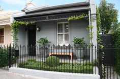 a house with a fence around it and a bench in the front yard