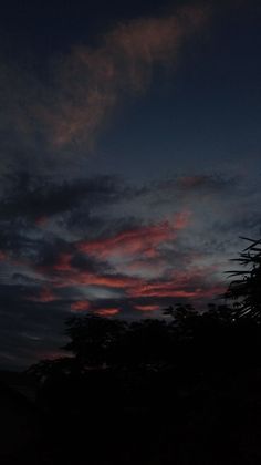 the sky is very dark and cloudy at night, with some clouds in the background