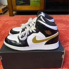 January 2019 Saw The Iconic Air Jordan 1 Mid Show Off A Glossy New Retool With The Se Gs ‘Black Gold’ Sneaker. This Kids' Offering Boasts A White Leather Upper With Tonal Laces, Golden Air Jordan Logo At The Tongue And Side, Along With A Metallic Gold Swoosh. Shiny Black Patent Material Heightens The Design, Appear At The Ankle, Eyestay, Heel, And Mudguard. Style Code: Bq6931-007 Size: 7y (40) Condition: Slightly Used But Like New.. Come With Original Box.. Jordan 1 Glossy, Nike Jordan Air 1, Tenis Jordan, Air Jordan Logo, Jordan Hats, Cheap Jordan Shoes, White Basketball Shoes, Top Basketball Shoes, Jordan Logo