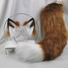 a cat standing next to a fake fox head