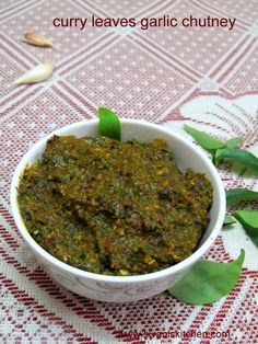 curry leaves garlic chutney in a white bowl on a red and white tablecloth