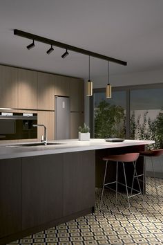 a modern kitchen with an island counter and bar stools