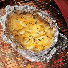 an image of food cooking on the grill with foil wrapper over it's side