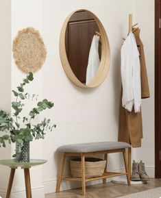 a room with a bench, mirror and coat rack