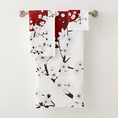 two red and white towels hanging on a towel rack in front of a white wall