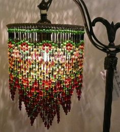 a chandelier made out of beads hanging from a light fixture on a wall