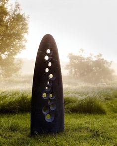 a sculpture in the middle of a grassy field