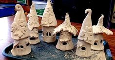 seven clay gnome houses sitting on top of a tray