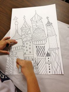 a person is drawing a castle on paper