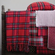 a bed with red and black plaid blankets on it