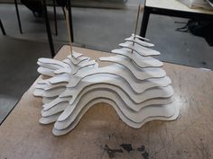 a wooden table topped with white sculptures on top of it