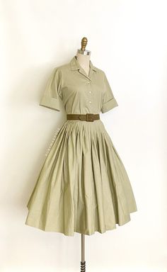 "vintage dress  Era: 1950's Label: Miss Pat. California. Sanforized. Closure: top * button front, skirt * side metal zipper, button waist Material: cotton Colour: muted olive green  Details: versatile two piece top and skirt set, original matching belt, timeless silhouette, optional turn up cuffs, full pleated skirt Fits like: small * top * Bust: 39\" Shoulders: 14.5\" Waist: 36\" Length: 22\" * skirt * Waist: 26\" Hips: free Length: 28\" (5.5\" hem allowance) Condition: The set feels like its never been worn/possibly deadstock. The top has a tiny spot on the back of the hem. Skirt is in excellent condition. Priced accordingly.   shop policy  * All items are a final sale. No returns, exchanges and, order cancellations are not accepted.  * Ruby Mae Rose is not responsible for lost or stolen Two Piece Top And Skirt, Muted Olive Green, Ruby Mae, Matching Skirt Set, Vintage Romper, Muted Green, Skirt And Top Set, Belt Dress, Rose Vintage