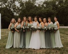 a group of women standing next to each other on top of a grass covered field