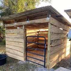 an outhouse made from pallet wood with metal bars