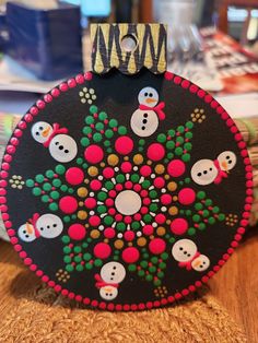 a black and red christmas ornament sitting on top of a wooden table