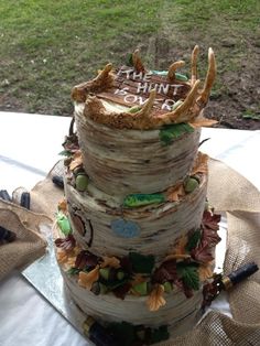 a three tiered cake is decorated with autumn leaves and an antler's head