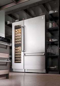 a stainless steel refrigerator in a kitchen with glass doors and shelves full of wine bottles