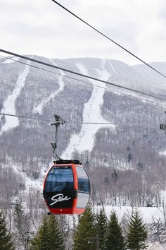 a ski lift with trees and mountains in the background