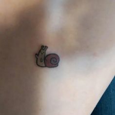 a small snail tattoo on the stomach