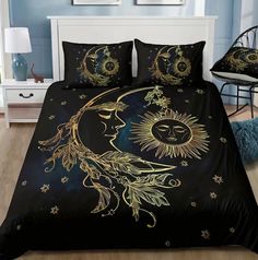 a bed covered in a black comforter with a gold sun and moon on it