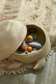 a hat sitting on top of a floor next to a basket filled with different items