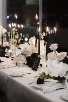 the table is set with white flowers and candles