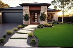 a modern house with landscaping in the front yard and driveway leading up to it's entrance