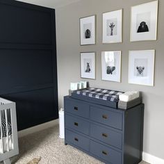 a baby's room with pictures on the wall and a crib in the foreground