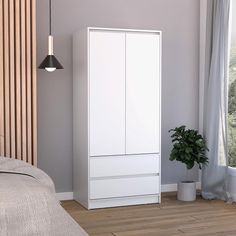 a white cabinet next to a bed with a plant in it and a window behind it