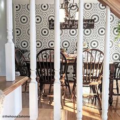 the dining room is decorated with black and white wallpaper, along with wooden chairs