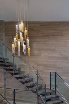 the chandelier is hanging from the ceiling above the stairs in this modern home