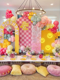 a table topped with lots of balloons and decorations